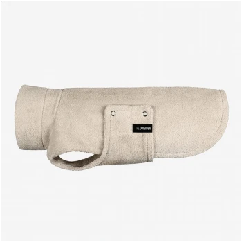 Ein Hund, der einen beigen, weichen Fleece-Mantel trägt, steht stolz da und zeigt sein stilvolles Design und eine Tasche an der Seite.