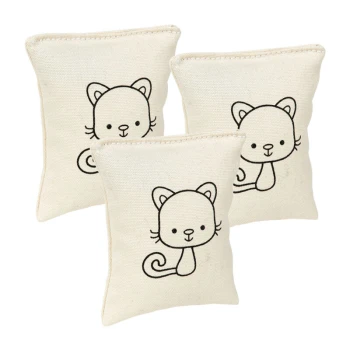 Drei kleine, cremefarbene katzenförmige Kissen mit einfachen schwarzen Lin Zeichnungen von Cartoon-Katzen auf jeder Seite.