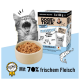 Gähnendes graues Kätzchen, Schale mit Nassfutter und DOGS'n TIGER-Box mit Aufschrift 'Mit 70% frischem Fleisch' und 'FREIGEIST'.