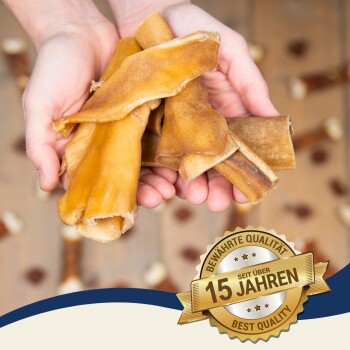 Eine Tüte Hundeleckerlis mit dem Aufdruck "Premium Qualität" und einem grünen "100% Natürlich" Aufkleber, umgeben von verschiedenen Kaustangen auf einer Holzoberfläche.