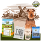 Ein brauner Hund sitzt neben einer Windmühle, umgeben von Haustierprodukten: Bellfor Hundefutter, einer "HUNDE LIEB HABER" Tasche, Shiimun Leckerlis und blauen Dental Sticks.
