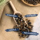 Getrocknete Insekten in einem Holzlöffel auf Jute mit deutschen Beschriftungen: proteinreich, Kraftquelle, natürlich, Nährstoffdichte.