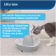 Eine grau-weiße Katze trinkt aus einem modernen, runden Wasserbrunnen mit sanftem Fluss, mit Text über seinen leisen Betrieb und Design.