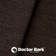 Nahaufnahme eines strukturierten dunkelbraunen Stoffes mit dem Logo 'Doctor Bark', das auf ein in Deutschland hergestelltes Haustierprodukt hinweist.