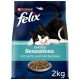 Un chat noir et blanc allongé à côté d'un bol de croquettes, présentant le produit "Felix Seaside Sensations" avec du saumon et des légumes, 2kg.