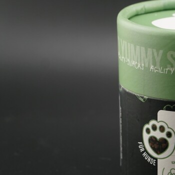 Grüner zylindrischer Behälter mit Hundesnacks im Pfotenabdruckdesign, mit dem Text "Yummy Snacks" und "Für Hunde."