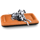 Ein Dalmatiner-Hund ruht bequem auf einem orange-schwarzen Haustierbett und zeigt seine charakteristischen schwarzen Flecken auf einem weißen Fell.