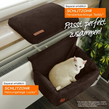 Eine weiße Katze entspannt sich in einem braunen Haustierbett auf einer Fensterbank, zeigt "Fensterbankliege Teddy" und "Heizungsliege Lucky" mit "Passt perfekt zusammen!"