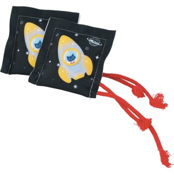 Two black square catnip toys printed with yellow rocket and cat in porthole, space stars and red braided tassels.