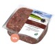 Ein quadratisches weißes Geschirr, gefüllt mit rohem, fein gehacktem rotem Fleisch, auf einer Holzoberfläche platziert.