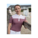 Eine Person, die ein stilvolles, kurzärmliges, kastanienbraunes und weißes Poloshirt trägt, steht an einem Holzzaun, mit einem verschwommenen Hintergrund.