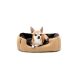 Ein kleiner tan- und weißer Chihuahua, der sich in einem gemütlichen, plüschigen Hundebett mit einem beigen Äußeren und einem dunkelbraunen Inneren entspannt.