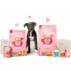 Ein verspielter Welpe steht zwischen zwei Säcken Edgard Cooper Hundefutter, mit einer Dose und zwei Schalen Nassfutter in der Nähe.