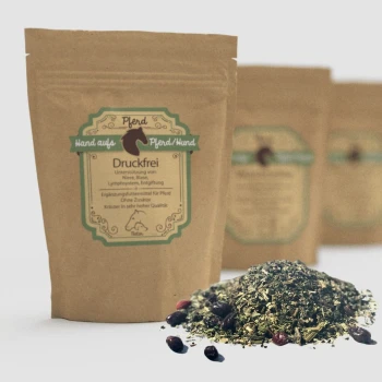 Eine "Druckfrei" braune Papiertüte mit grünem Design enthält Kräuterergänzungen für Haustiere, mit verschütteten getrockneten Kräutern und Beeren davor.