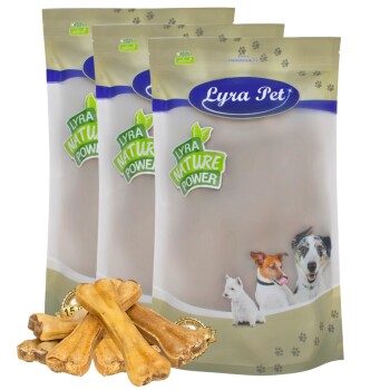 Drei Tüten Lyra Pet Nature Power Hundeleckerlis mit verschiedenen Hundebildern auf der Verpackung, begleitet von mehreren Kauknochen im Vordergrund.