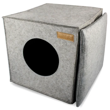 Grauer Filzhaustierwürfel mit einem runden Eingang und einem Lederschild mit der Aufschrift 'Kama Luma.'