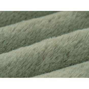 Nahaufnahme von weichem, grau-grünem Plüschstoff, wahrscheinlich ein Haustierbett oder eine Decke, mit flauschiger Textur.