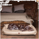 Zwei braune Hunde schlafen friedlich auf einem beigen Hundebett in einem gemütlichen Raum mit einer Ziegelwand und einem Holzbett im Hintergrund.