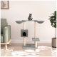 Ein moderner Katzenbaum mit einem grauen und beigen Design, mit zwei Plattformen, einem gemütlichen Versteck und einer verspielten getigerten Katze, die oben sitzt.
