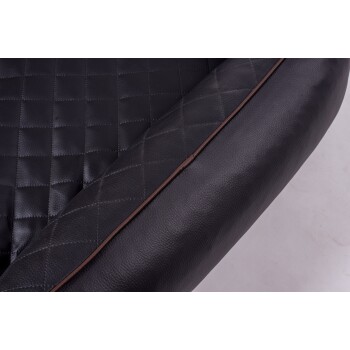 Nahaufnahme eines schwarzen Haustierbettes mit einem gesteppten Design und einer glatten, abgerundeten Kante, das seine plüschige Textur zeigt.