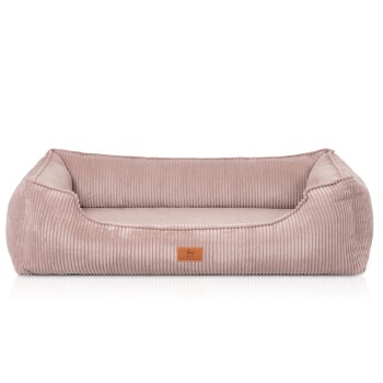 Rechteckiges blassrosa Cord-Hundebett mit erhöhten Seiten und kleinem Lederetikett mit Hundesymbol.