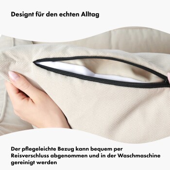 Nahaufnahme einer Hand, die einen Reißverschlussbezug für ein Haustierbett hält, der seine abnehmbare, waschbare Eigenschaft hervorhebt. Text: "Für das echte Leben entworfen."