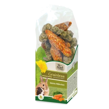 Eine durchsichtige Tüte mit bunten, karottenförmigen Snacks für kleine Haustiere, beschriftet mit "JR FARM Grainless Glücks-Möhrchen", mit einem Kaninchen und einem Meerschweinchen.
