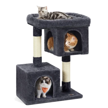 Ein grauer Katzenbaum mit zwei Ebenen: eine graue getigerte Katze, die oben entspannt, und eine orangefarbene Katze sowie eine flauschige weiße Katze in den geschlossenen Bereichen darunter.
