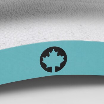 Nahaufnahme eines Haustierprodukts mit einem türkisfarbenen Rand und einem schwarzen Ahornblatt-Logo auf einem strukturierten weißen Hintergrund.