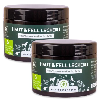 Zwei Gläser "Haut & Fell Leckerli," ein Hundefutterergänzungsmittel, mit grünen Etiketten, die in deutscher Sprache angeben, dass es aus 100% recyceltem Material hergestellt ist.