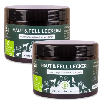 Zwei Gläser "Haut & Fell Leckerli," ein Hundefutterergänzungsmittel, mit grünen Etiketten, die in deutscher Sprache angeben, dass es aus 100% recyceltem Material hergestellt ist.