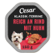 Cesar Hundefutteretikett mit der Aufschrift 'KLASSIK-TERRINE REICH AN RIND MIT HUHN, 150 g', einem lächelnden weißen Hund und Fleisch auf einem Teller.