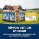 Golden Retriever sitzt auf Gras mit M!EAT Hundefuttertüten und einem Schild über zertifizierten Tierschutz auf Deutsch.