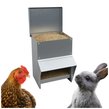 Metall-Pellet-Futterspender, gefüllt mit Pellets, flankiert von einem Huhn (links) und einem grauen Kaninchen (rechts).
