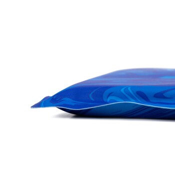 Nahaufnahme eines blauen Haustierbettes mit einem wellenförmigen Muster, das seine weiche, gepolsterte Kante vor einem weißen Hintergrund zeigt.