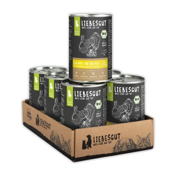 Liebesgut Dosen-Bio-Welpenfutter im Kartontray, schwarze Etiketten mit Puten-Skizze und 'BIO'-Logo.