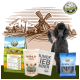 Ein schwarzer Pudel steht neben Tierprodukten: BELLEFOR Hundefutter, SHIIMUN Ergänzung, eine Tragetasche und Zahnsticks, mit einer ländlichen Kulisse.