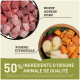 Cubes de viande crue dans un bol étiqueté "Boeuf, Agneau, Porc" à côté d'une assiette en bois avec de la citrouille et de la pomme, indiquant "50% d'ingrédients animaux de qualité."