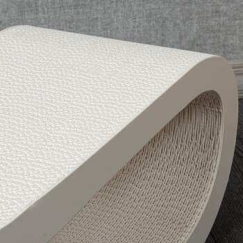 Eine Nahaufnahme eines strukturierten, weißen Haustierkratzpfostens mit einem gebogenen Design, vor einem grauen Hintergrund.