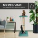 Ein gemütlicher Katzenbaum mit zwei Katzen, eine sitzt auf einer gepolsterten Plattform und die andere klettert, umgeben von Zimmerpflanzen und Möbeln.