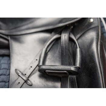 Nahaufnahme eines schwarzen Ledersattels mit einem sichtbaren Steigbügel, der mit 'EQUINATE' beschriftet ist, und der sein schlankes Design und Handwerkskunst zeigt.