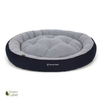 Rundes Haustierbett mit einem plüschigen grauen Zentrum und einem dunklen marineblauen Rand, mit dem "Doctor Bark"-Logo und einem "Green Label"-Emblem.