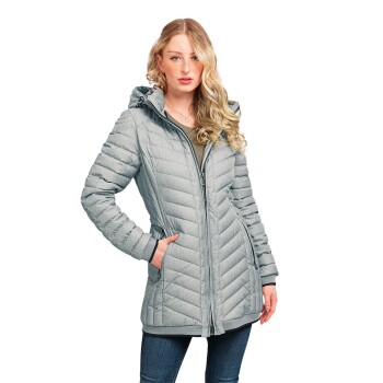 Eine Frau trägt eine hellgraue, gesteppte Jacke mit Kapuze, die über einen Reißverschluss an der Vorderseite und seitlichen Taschen verfügt, und steht selbstbewusst.