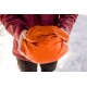 Eine Person in einer kastanienbraunen Jacke hält eine kompakte, leuchtend orangefarbene Haustiertrage oder -tasche, umgeben von Schnee.