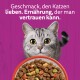 Katze über einem Futternapf auf violettem Hintergrund mit Text: „Geschmack, den Katzen lieben. Ernährung, der man vertrauen kann.“
