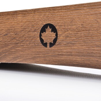 Nahaufnahme eines Holz-Haustierprodukts mit einem schwarzen Ahornblatt-Logo, das die Maserung und Textur des Holzes zeigt.