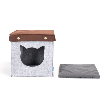 - Katzenhaus Quadratisch aus Filz Graues Filz-Katzenhaus mit einem braunen Dach und einem katzenförmigen Eingang, begleitet von einem grauen Kissen.