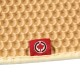 Nahaufnahme einer haifischmusternden Haustiermatte in Beige, mit einem kleinen roten Etikett mit einem weißen Ahornblatt-Logo.
