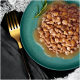 Gros plan sur une assiette teal remplie de nourriture pour animaux humide et hachée dans une sauce, garnie d'une branche de romarin, à côté d'une fourchette dorée.