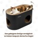Schwarze Katze kratzt an einem ovalen schwarzen Papp-Katzenhaus/Kratzmöbel mit runden Löchern und weißem ‚Petrhein‘-Logo im Wohnzimmer.